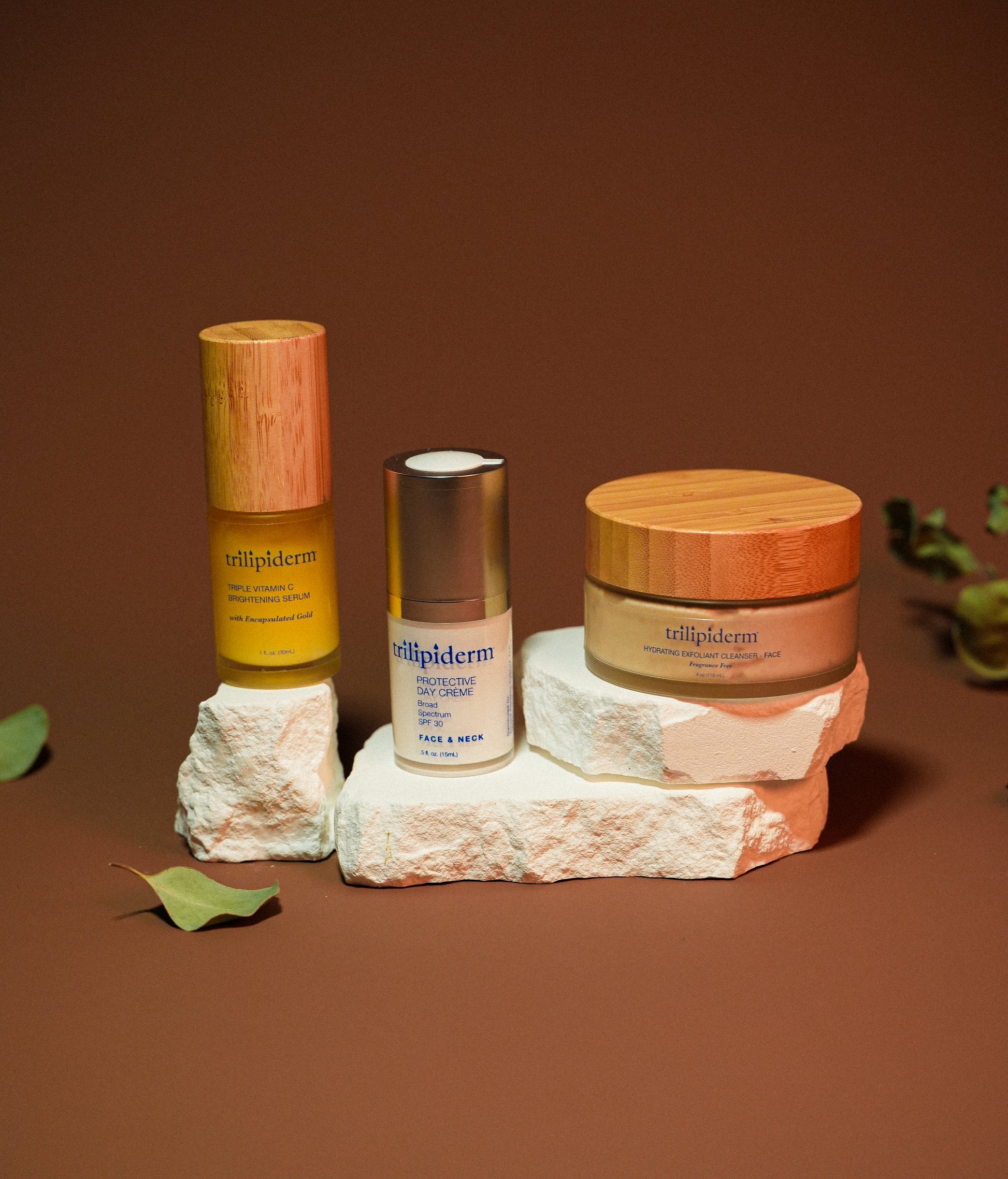 Three skincare products from the brand 'tellipiderm' on a textured surface with a brown background.
