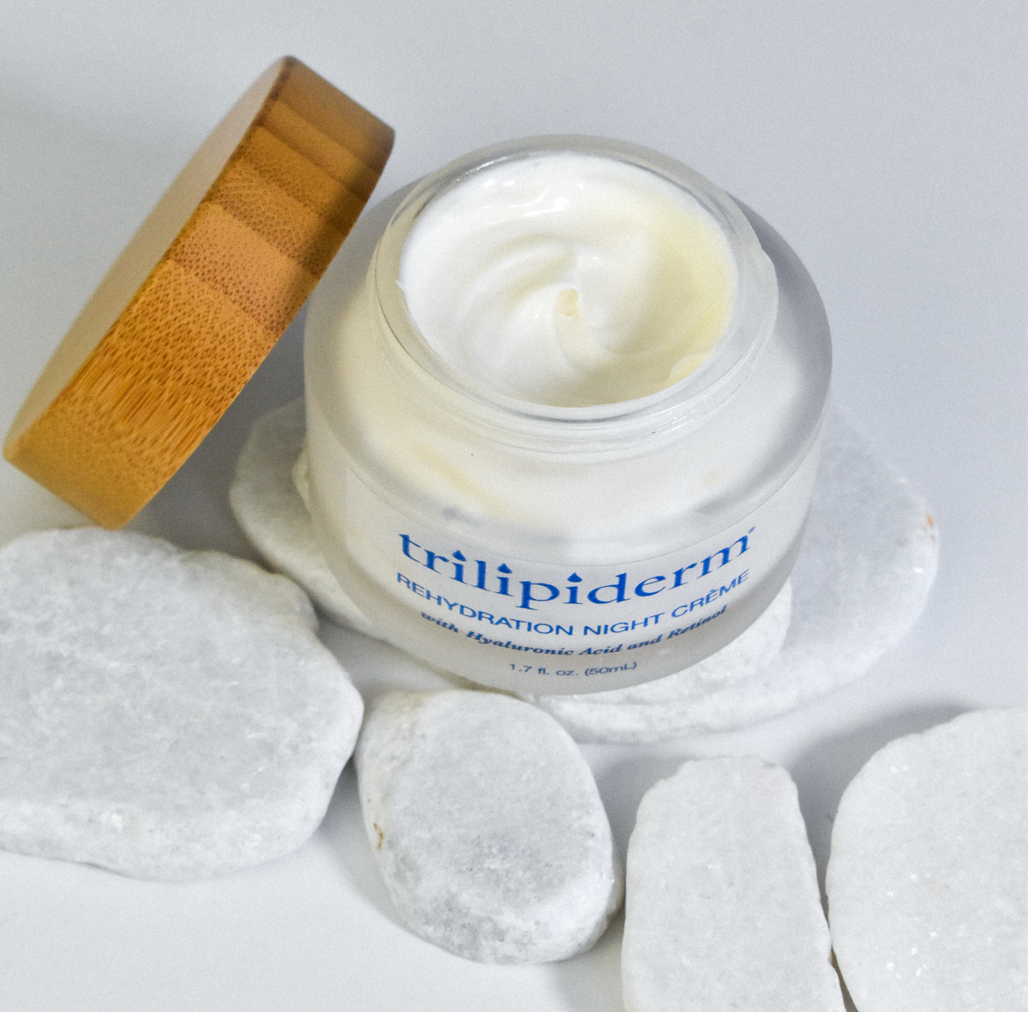 above view of night creme displayed on white rock and bamboo cap