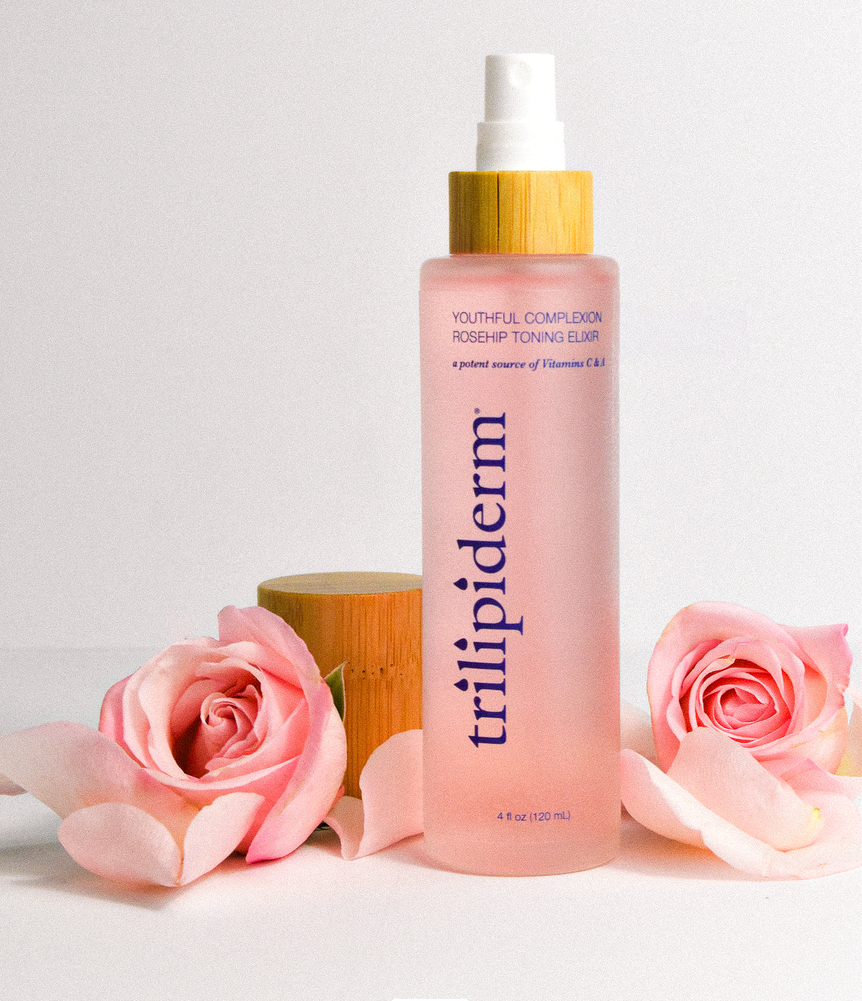 trilipiderm pink toner with clear glass bottle and bamboo cap surrounded by pink flowers with a pink hued background
