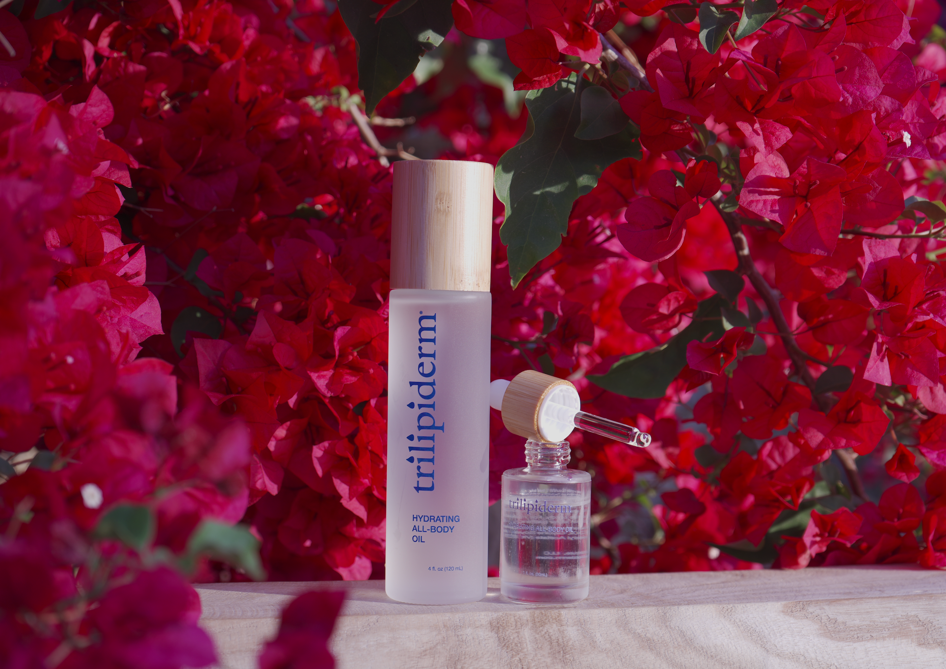 Two skincare bottles with a red floral background