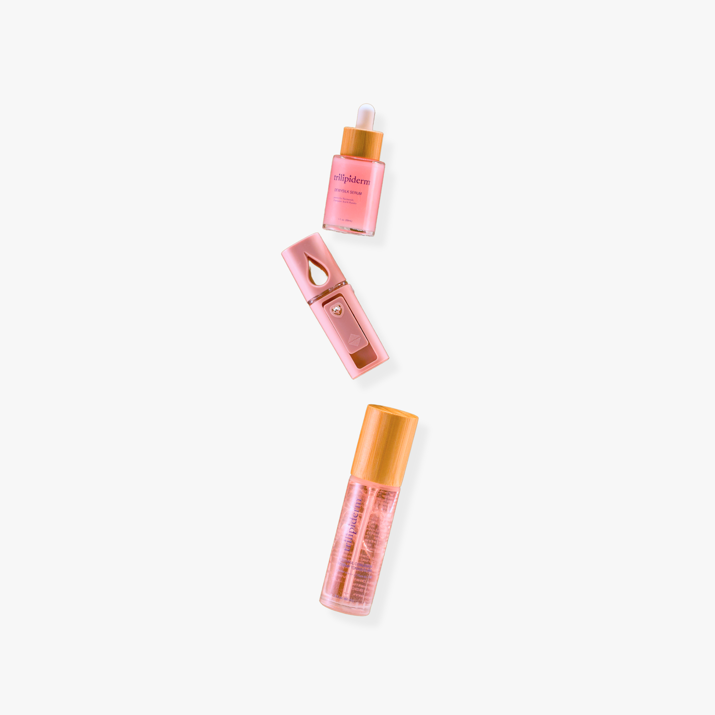 Trilipiderm DewySilk Serum, Rosehip Toner, and mini pink skincare tools arranged vertically at an angle on white background.