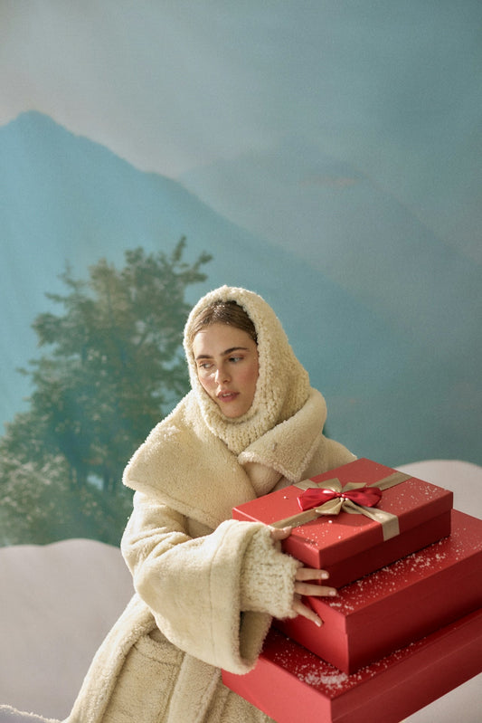 Woman holding wrapped holiday gifts after finding the perfect Trilipiderm skincare presents.