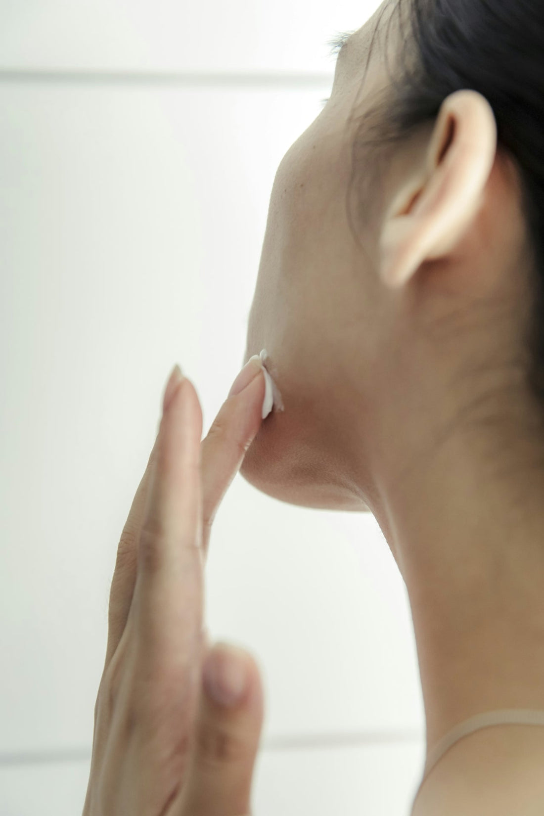 Woman applying Trilipiderm Advanced Retinol Treatment to her neck as part of a 60-day nighttime skincare routine for anti-aging and skin renewal