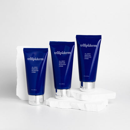 Three blue tubes of trillipiderm cream on a white background and white rock