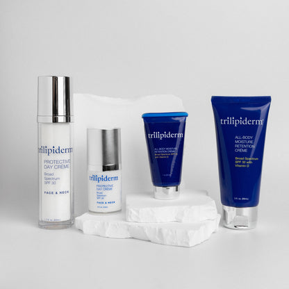 Trillipiderm skincare products on a light gray background and white rock