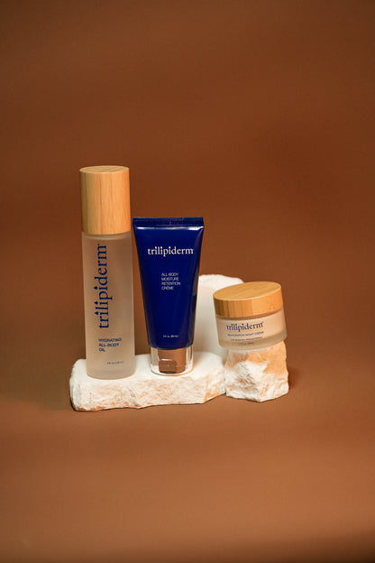 Trilipiderm skincare products on a stone surface with a brown background