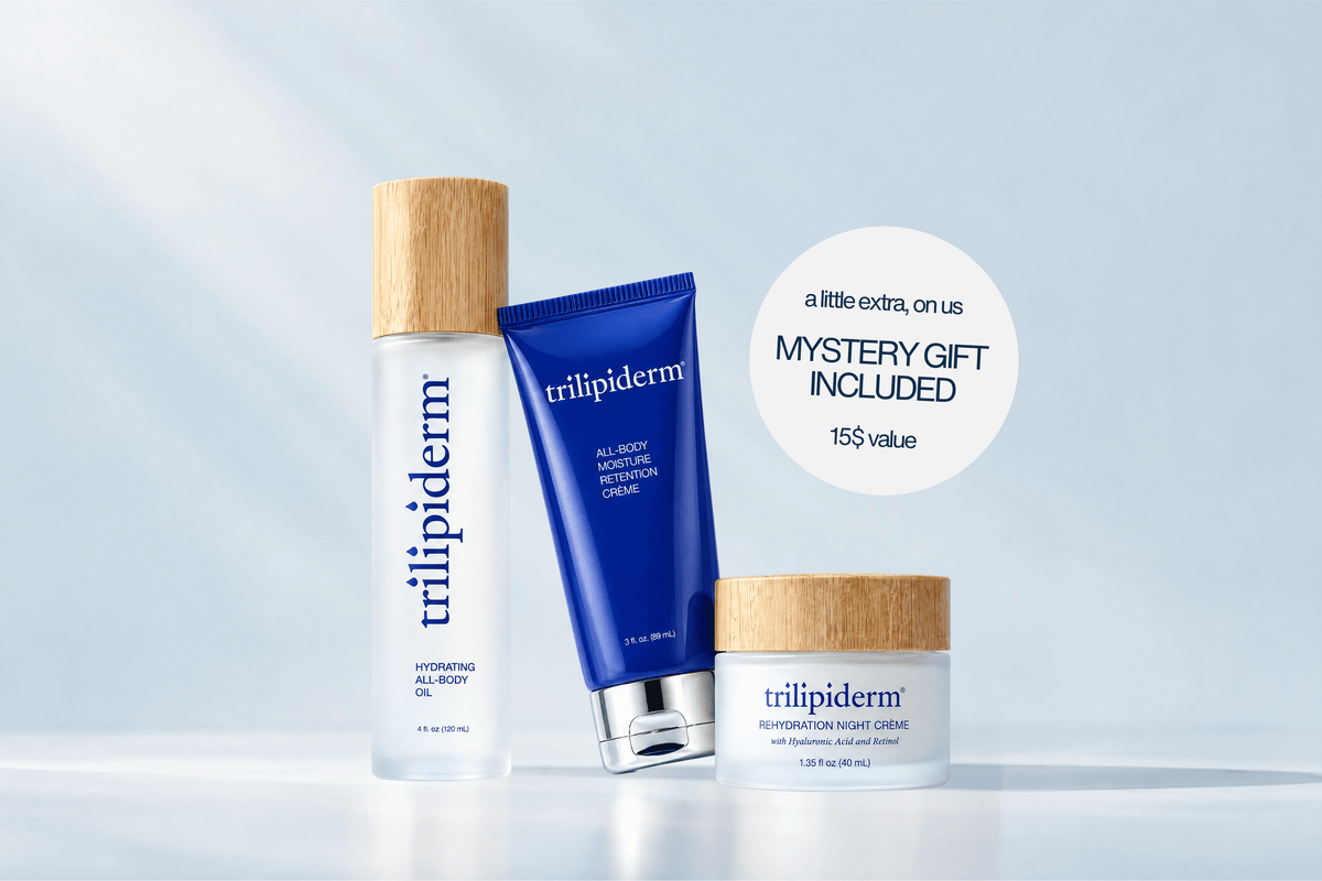 Three Trilipiderm skincare products arranged on a light blue-white background: a tall clear bottle with a bamboo cap, a blue tube with a silver cap, and a small frosted jar with a bamboo lid. A white circular callout reads 'a little extra, on us.