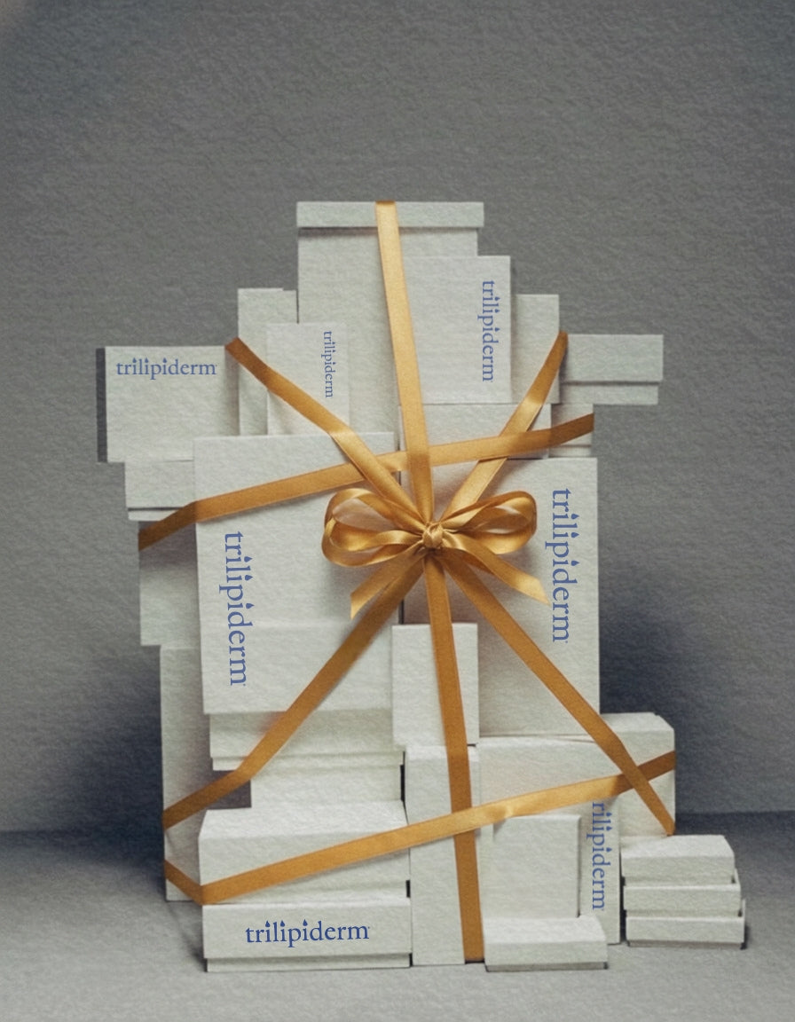 Stack of 'trillpiderm' boxes tied with a gold ribbon on a gray background