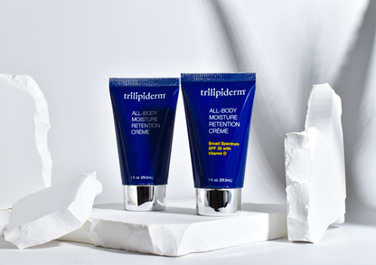two tubes of trilipiderm lotion displayed on white rock with white background