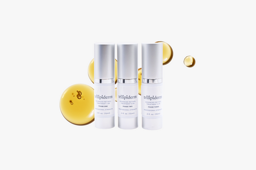 Three bottles of Retinol serum with yellow droplets on a white background with swatch