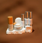 Skincare products on a stone platform with a brown background