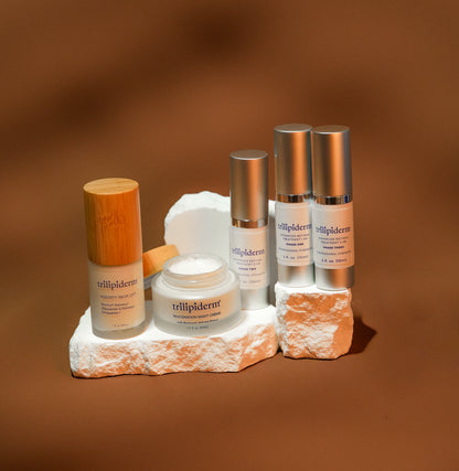 Skincare products on a stone platform with a brown background