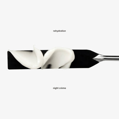 White cream being spread on a black background with 'rehydration' and 'night crème' text. The rehydration night crème showing hydrating rich night cream with retinol and hyaluronic acid. Rich overnight repair for all skin types.