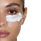 Close-up editorial skincare image of a model with rich white crème texture applied under the eye, representing Trilipiderm Rehydration Night Crème hydration benefits, retinol-powered overnight care, and a smooth, dewy, refreshed-looking complexion.