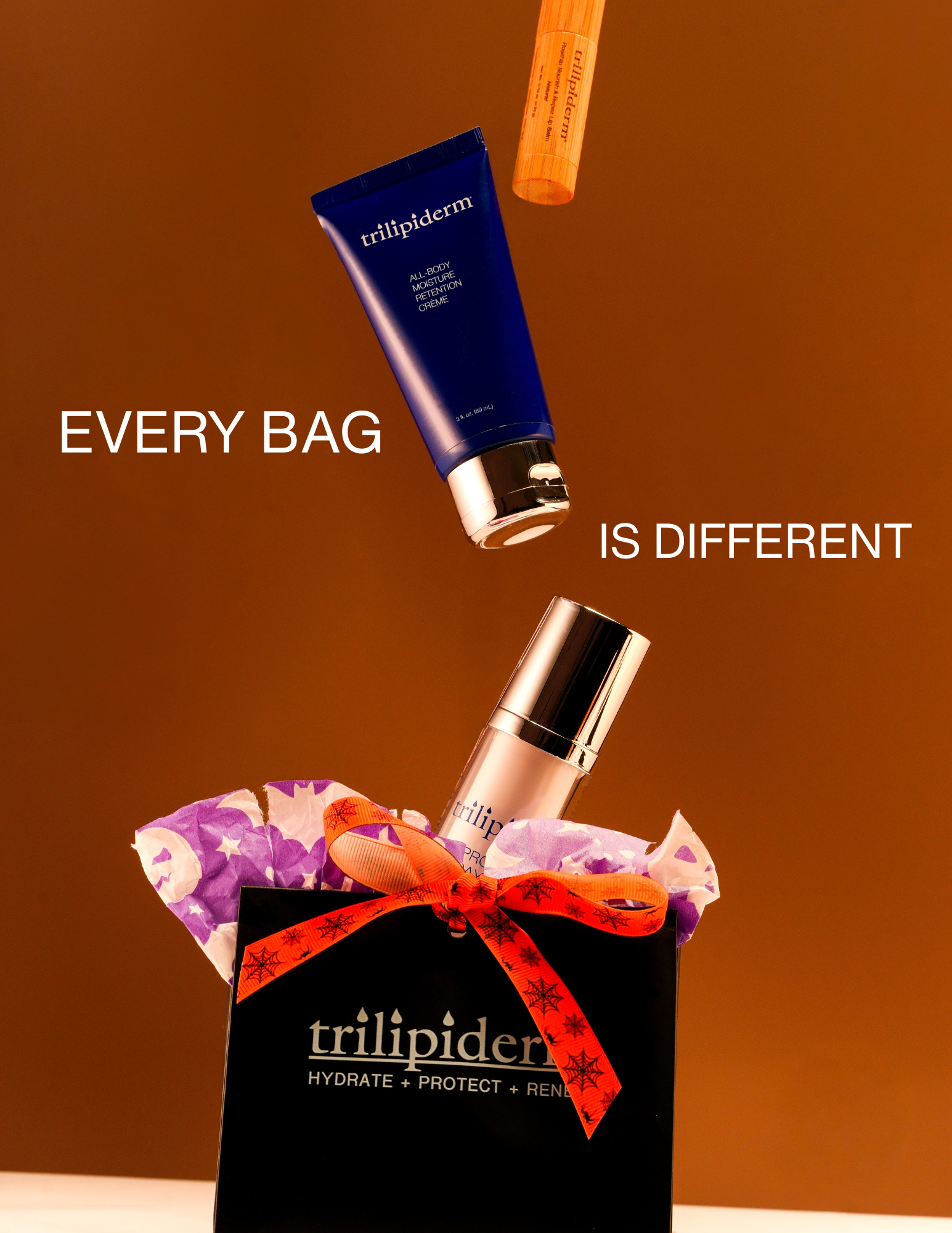 Trilipiderm Halloween Mystery Bag with assorted skincare products and orange spider ribbon, highlighting every bag is different.