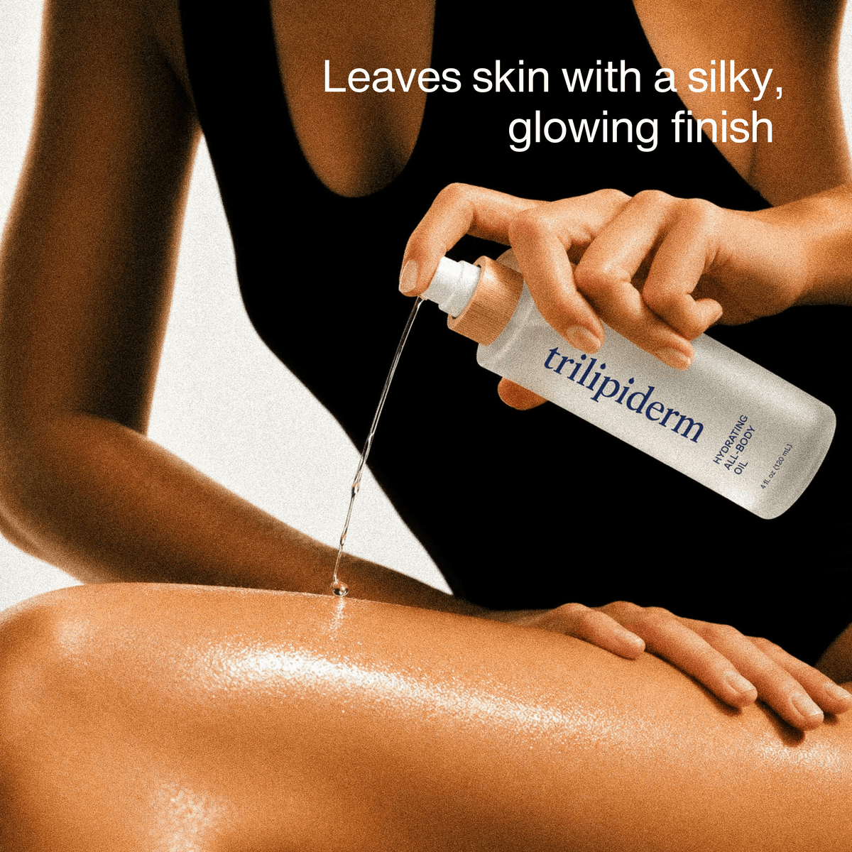 Model applying Trilipiderm Hydrating All-Body Oil to her leg, showing the lightweight oil texture and silky, luminous finish on moisturized skin.