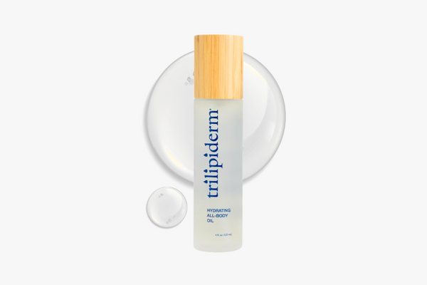 Trilipiderm hydrating all-body oil bottle with wooden cap on a white background and swatch