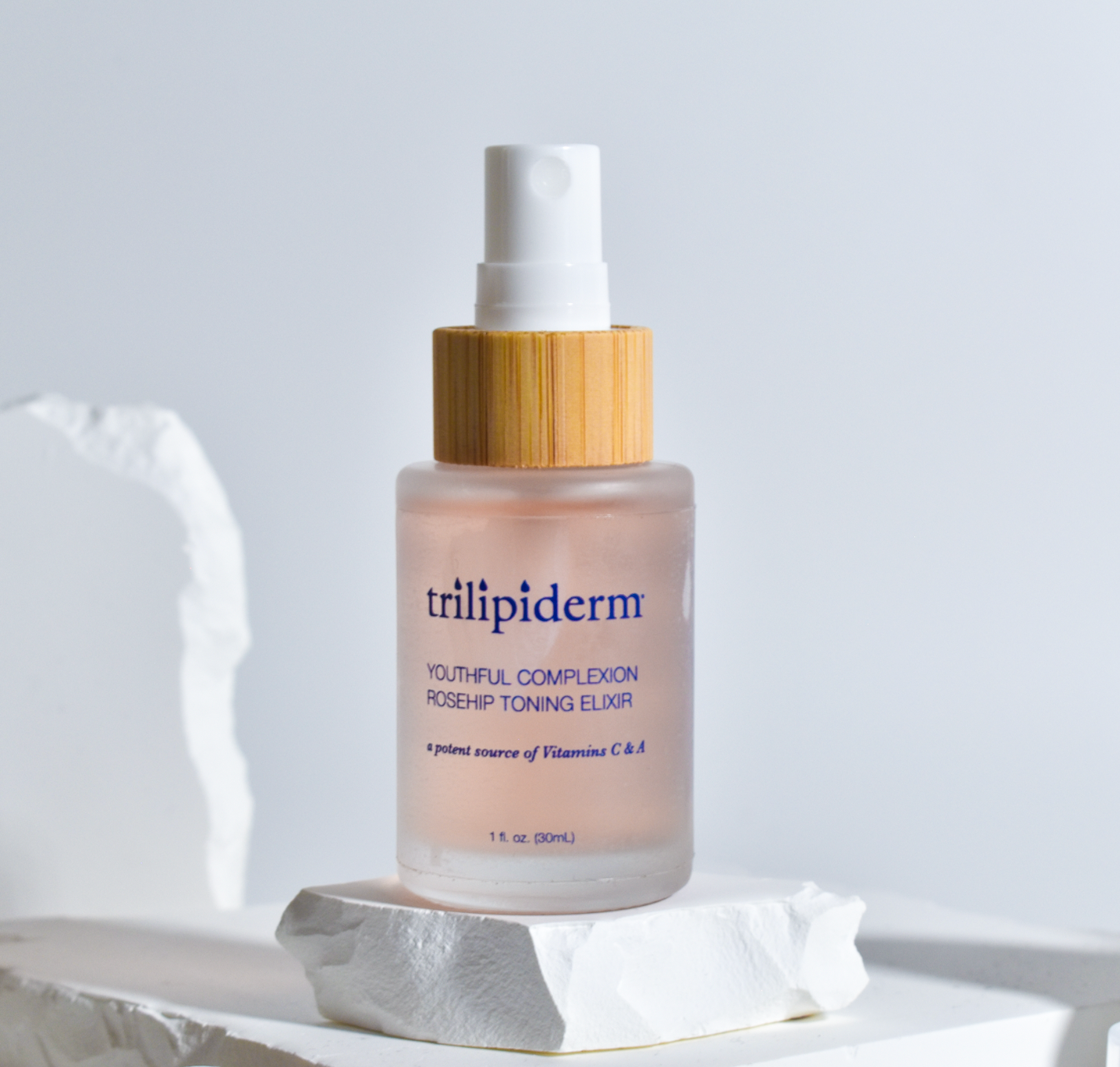 Trilipiderm Rosehip Facial Mist Hydrating Toner spray bottle product photo on white background. Luxury facial mist toner for barrier-friendly hydration, soothing comfort, and dewy glow. Clean skincare toner for all skin types including sensitive.