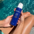 moisture retention creme spf 30 held by model with blue tube and white airless pump